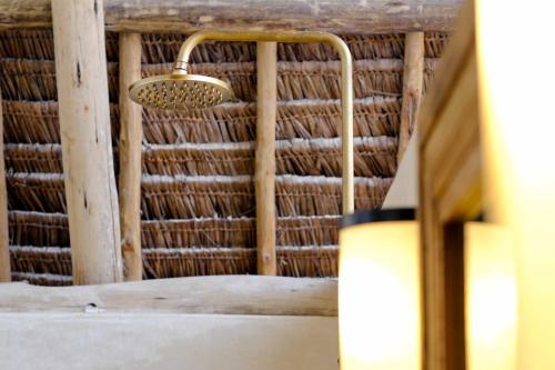 a bathroom with a basket hanging from the ceiling at Baladin Zanzibar Beach Hotel in Michamvi