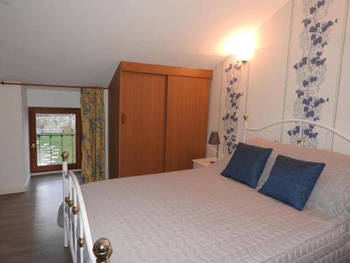 a bedroom with a white bed with blue pillows at COUR LA DAME chez Béatris et Christophe Janson in Les Grandes-Loges