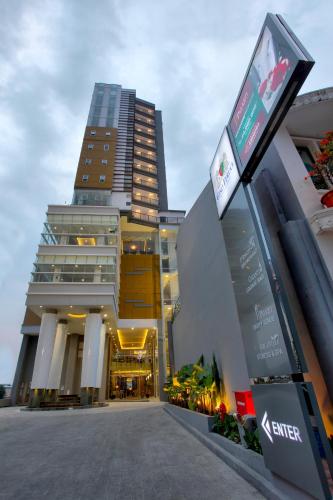 a tall building with a sign in front of it at Gino Feruci Braga by KAGUM Hotels in Bandung