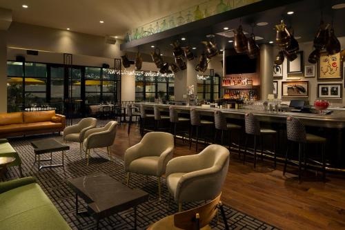 a bar in a restaurant with chairs and a bar counter at Hotel ZaZa Houston Memorial City in Houston