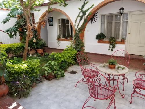 un patio con mesa, sillas y plantas en Linda Casa Acogedora, en Tarija