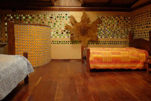 a bedroom with two beds and a wooden floor at Tree House Beachfront Lodge in Puerto Viejo