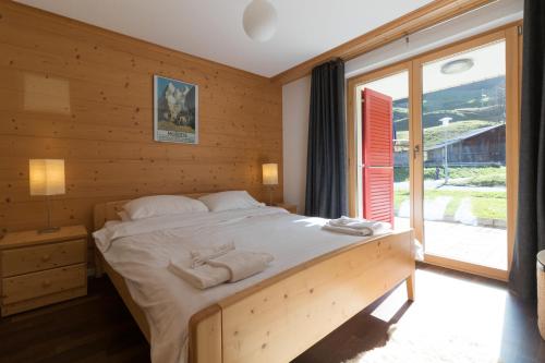 a bedroom with a large bed with towels on it at Chalet Brunner 3 in Wengen