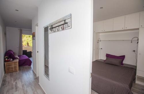 アデへにあるMareverde Apartamentのベッドルーム(紫色の枕が付くベッド付)