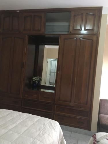 a large wooden cabinet with a mirror in a bedroom at Casa Acogedora Tarija in Tarija
