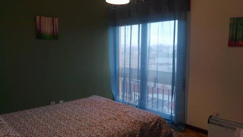 um quarto com uma cama e uma grande janela em Domus Bracari em Braga