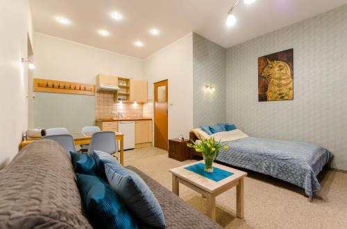 een woonkamer met een bank en een bed bij Central Krak Apartments - studios in Krakau