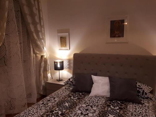 - une chambre avec un lit et des oreillers noirs et blancs dans l'établissement La Casa di San Francesco, à Assise