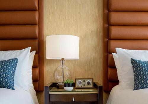 a hotel room with two beds and a lamp on a table at Dossier in Portland