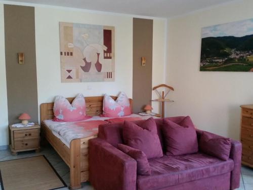 sala de estar con sofá y almohadas rosas en Ferienwohnung Pollig, en Rech