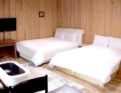 a bedroom with two beds and a desk and a bed sidx sidx sidx at Muju Rejortel in Muju
