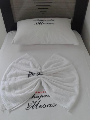 a bed with two pillows and a white blanket at Pousada Chapada das Mesas in Riachão