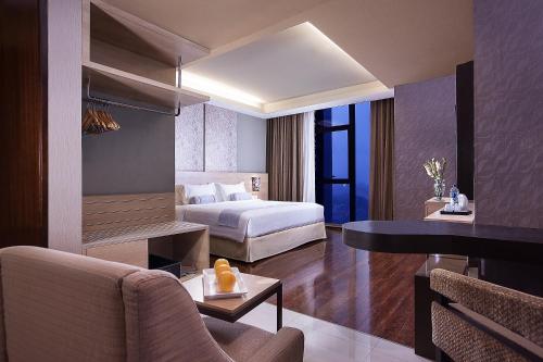 a hotel room with a bed and a desk at Harper Malioboro Yogyakarta by ASTON in Yogyakarta