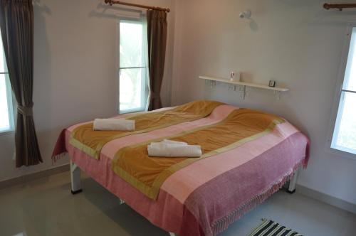 a bedroom with a bed with two towels on it at Ban Khan LeeMa in Sam Roi Yot