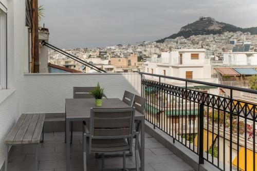 a balcony with a table and chairs and a view at Olympus Residence in Athens