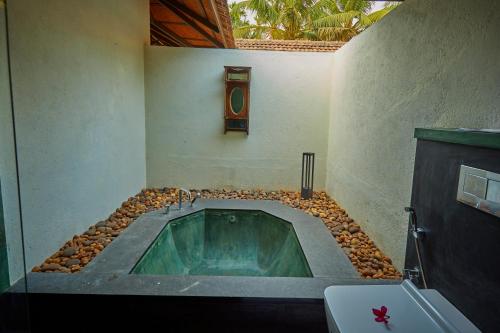 a bathroom with a tub in the corner of a room at Cranganor History Café & Riverside Château in Parūr