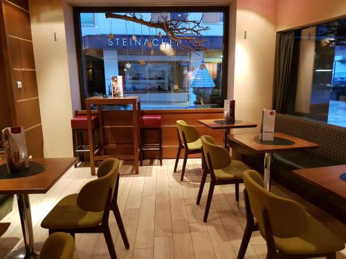 a restaurant with tables and chairs in front of a window at Pension Buchner in Zell am See