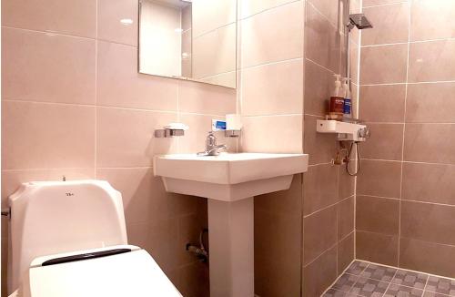 a bathroom with a sink and a toilet and a mirror at Muju Rejortel in Muju