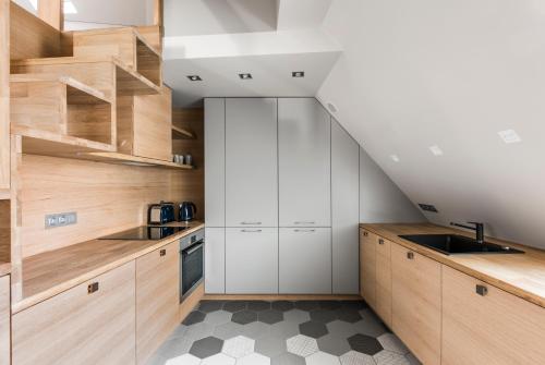 a kitchen with white cabinets and a staircase at City Entrance Apartment in Vilnius