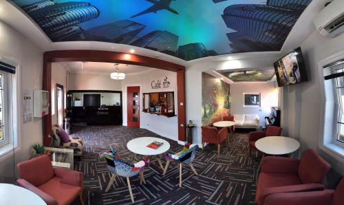 a waiting room with tables and chairs and a ceiling at Amelia Boutique Hotel in Brisbane