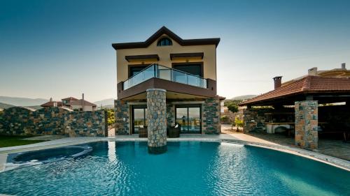 una casa con piscina frente a una casa en Villa St. Nicolas & Theano, en Agios Nikolaos