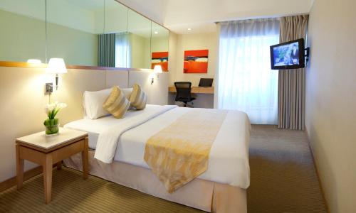 Habitación de hotel con cama grande y TV en Silka Maytower Kuala Lumpur, en Kuala Lumpur