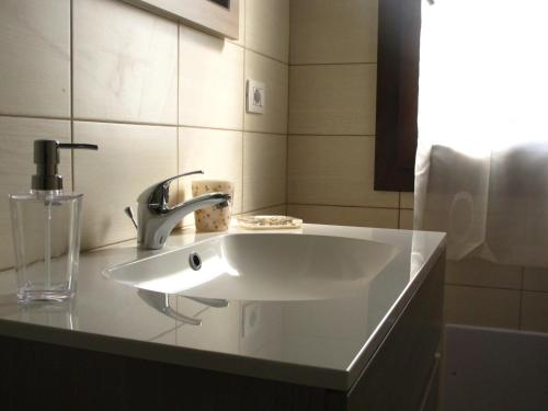a white sink in a bathroom with a window at Roccabianca in Sorso