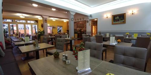 a restaurant with tables and chairs in a room at Hotel Alte Brennerei in Wernigerode