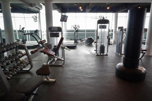 a gym with several treadmills and cardio machines at Midtown Residence Surabaya in Surabaya