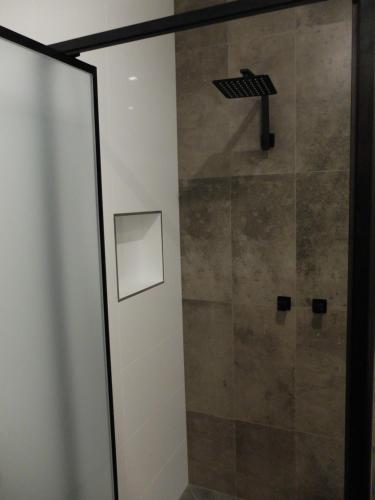 a bathroom with a shower with a glass door at Barooga River Gums Motor Inn in Barooga