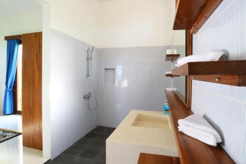 a white bathroom with a sink and a shower at Villa Nambung in Selong Belanak