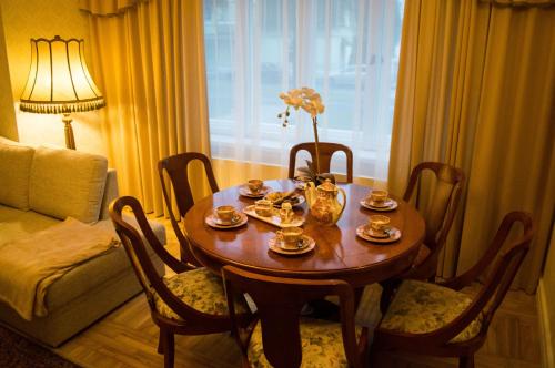 - une table à manger avec des chaises, une table et des fleurs dans l'établissement Ranna Luxury Apartment, à Pärnu