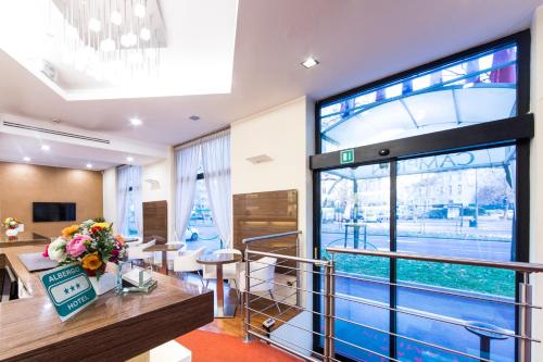 a lobby with a table and chairs and a large window at Hotel Campion in Milan