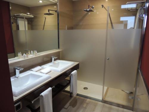 a bathroom with two sinks and a shower at Castillo Del Bosque La Zoreda in Manjoya