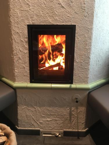 a brick fireplace with a fire in it at Agriroom in Rumo