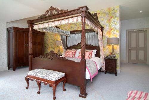 a bedroom with a large canopy bed with a bench at Rockhill House in Letterkenny