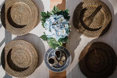 a vase of flowers and straw hats on a table at Cortijo Santa Clara in Carmona
