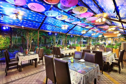 a restaurant with tables and chairs and a ceiling with umbrellas at Guangzhou The Royal Garden Hotel in Guangzhou