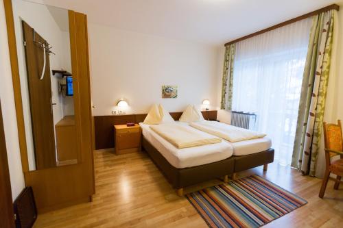 1 dormitorio con cama y ventana grande en Appartementhaus Lafenthaler mit kostenlosem Eintritt in Alpentherme, en Bad Hofgastein