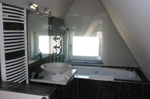 a bathroom with a sink and a bath tub at Villa Pica Paca - Old Town in Gdańsk