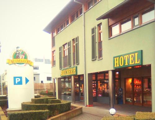 ein Hotelgebäude mit einem Schild davor in der Unterkunft Brasserie Beierhaascht in Niederkerschen