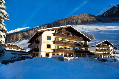 a building with a lot of snow in front of it at Berghotel Tyrol in Senales