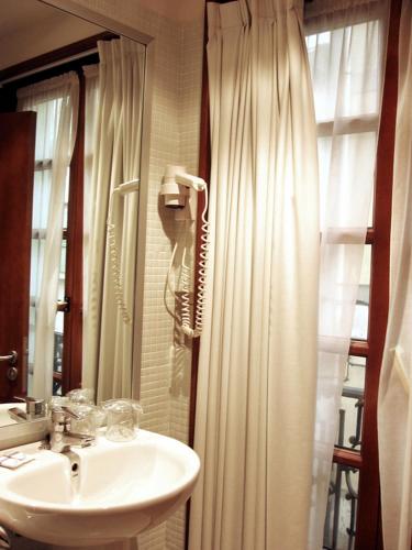 a bathroom with a sink and a shower curtain at La Plaza I in Luanco