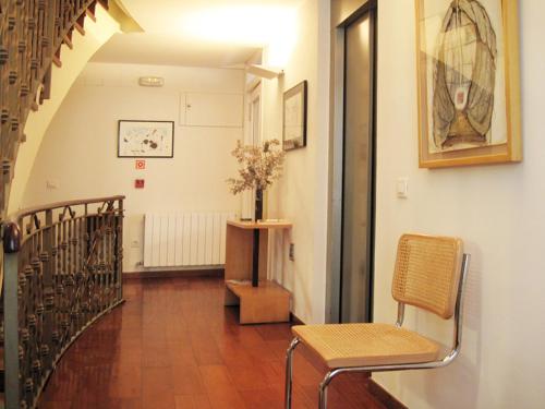 a hallway with a staircase with a chair and a table at La Plaza I in Luanco