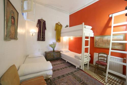 Zimmer mit 2 Etagenbetten und einem Sofa in der Unterkunft Bayt Alice Hostel in Tangier