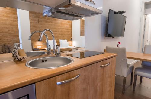 a kitchen with a sink and a desk with a tv at Luxury Apartments on Central Avenue in Tbilisi City