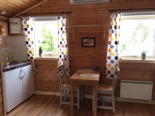 eine Küche mit einem Tisch und Stühlen in einer Hütte in der Unterkunft Lammsjon Relax in Sille