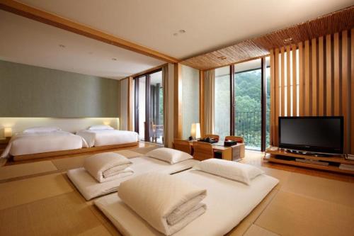 a bedroom with two beds and a flat screen tv at Hotel Royal Chiao Hsi in Jiaoxi