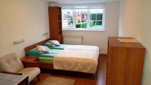 a small bedroom with a bed and a window at Apartament Tuwima 17 in Świnoujście