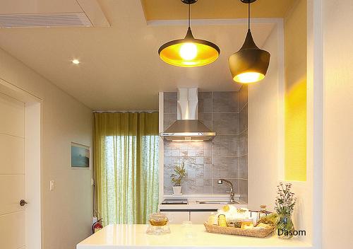 a kitchen with two lights and a counter top at Comma&Spa Resort in Seogwipo